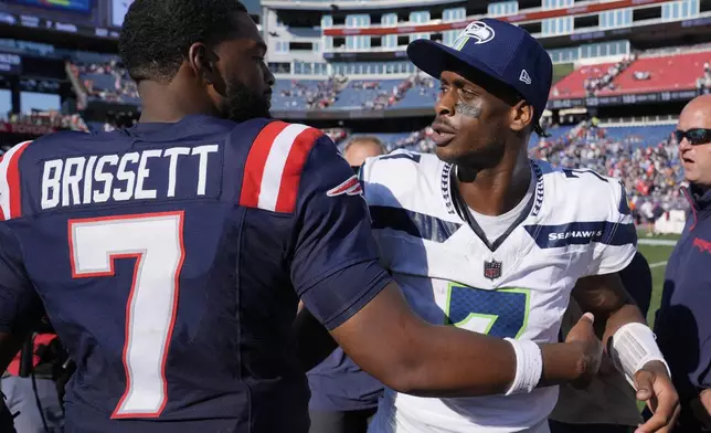 New England Patriots quarterback Jacoby Brissett, left, and Seattle Seahawks quarterback Geno Smith, greet one another in the center of the field following an NFL football game, Sunday, Sept. 15, 2024, in Foxborough, Mass. (AP Photo/Charles Krupa)