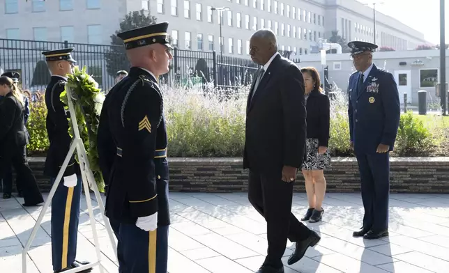 Defense Secretary Lloyd Austin steps toward a wreath at the start of the 9/11 observance ceremony at the Pentagon on Wednesday, Sept. 11, 2024 in Washington. At right is Chairman of the Joint Chiefs of Staff Gen. Charles Q. Brown Jr. (AP Photo/Kevin Wolf)