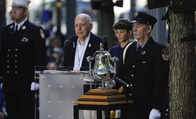 A a bell is rung at 9:03a.m. by a member of the FDNY during the 9/11 Memorial ceremony on the 23rd anniversary of the Sept. 11, 2001 terror attacks, Wednesday, Sept. 11, 2024, in New York. (AP Photo/Pamela Smith)