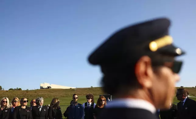 Airline employees pause at the Flight 93 National Memorial on the 23rd anniversary of the Sept. 11, attacks in Shanksville, Pa., Tuesday, Sept. 11, 2024. (AP Photo/Jared Wickerham)