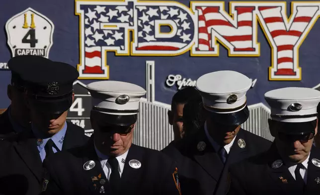 New York City firefighters bow their heads during a moment of silence outside Engine 4 Ladder 15 on the 23rd anniversary of the Sept. 11, 2001 attacks, Wednesday, Sept. 11, 2024, in New York. (AP Photo/Stefan Jeremiah)