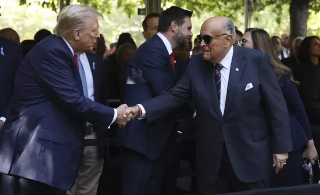 Republican presidential nominee former President Donald Trump greets Rudy Giuliani while attending the 9/11 Memorial ceremony on the 23rd anniversary of the Sept. 11, 2001 terror attacks, Wednesday, Sept. 11, 2024, in New York. (AP Photo/Yuki Iwamura)