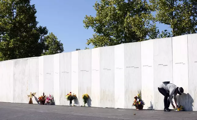 A family member of Captain Jason M. Dahl lays flowers in front of his name at the Memorial Plaza at the Flight 93 National Memorial on the 23rd anniversary of the Sept. 11 attacks in Shanksville, Pa., Wednesday, Sept. 11, 2024. (AP Photo/Jared Wickerham)