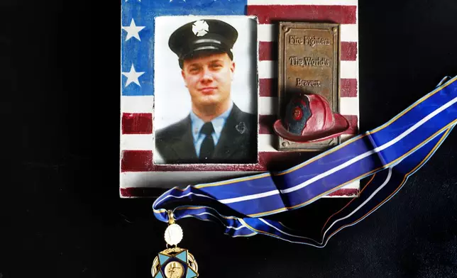 A photo of New York firefighter Christopher Michael Mozzillo, who died in the 9/11 attacks, with his 9/11 Medal of Valor is shown, Saturday, Sept. 7, 2024, in Freehold, N.J.. (AP Photo/Noah K. Murray)