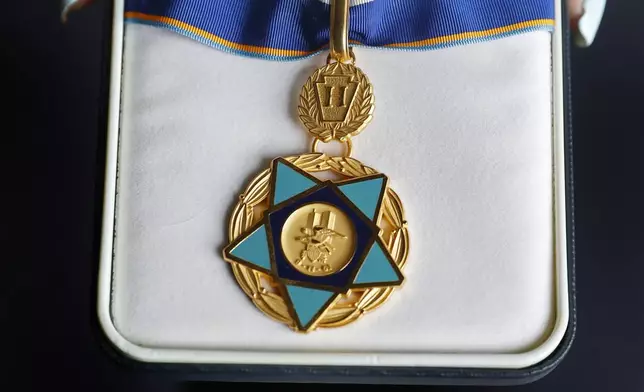 Pamela Yarosz holds the 9/11 Medal of Valor that was given to her brother and New York firefighter Christopher Michael Mozzillo, who died in the 9/11 attacks, Saturday, Sept. 7, 2024, in Freehold, N.J.. (AP Photo/Noah K. Murray)