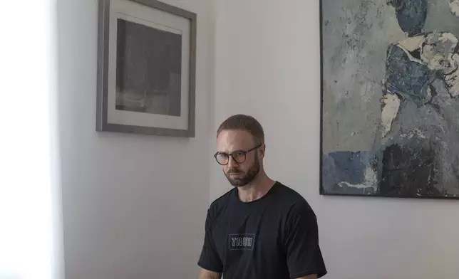 Andrei Hniot, a filmmaker and a prominent critic of the authoritarian government in Belarus, poses for a portrait in his apartment while under house arrest in Belgrade, Serbia, on Friday, Sept. 6, 2024. (AP Photo/Marko Drobnjakovic)