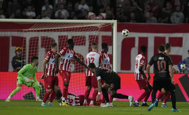 Benfica's Orkun Kokcu, right, scores a free kick, his side's second goal during the Champions League opening phase soccer match between Red Star and SL Benfica, at the Rajko Mitic Stadium in Belgrade, Serbia, Thursday, Sept. 19, 2024. (AP Photo/Darko Vojinovic)