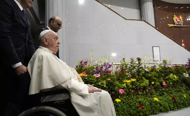 Pope Francis arrives with the President of the Singapore Republic Tharman Shanmugaratnam, third from left, for a visit to the Parliament House in Singapore, Thursday, Sept. 12, 2024. Pope Francis flew to Singapore on Wednesday for the final leg of his trip through Asia, arriving in one of the world's richest countries from one of its poorest after a record-setting final Mass in East Timor. (AP Photo/Gregorio Borgia)