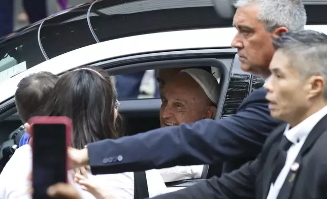 Pope Francis blesses a child as he departs National University of Singapore after delivering the state address in Singapore, Thursday, Sept. 12, 2024.(AP Photo/Suhaimi Abdullah)