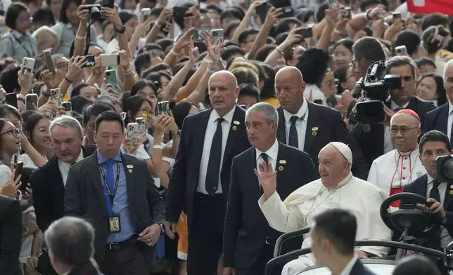 Pope Francis arrives at Singapore SportsHub National Stadium to preside over a mass celebrated by the Archbishop of Singapore, Cardinal William Goh Seng Chye, right, Thursday, Sept. 12, 2024. Pope Francis flew to Singapore on Wednesday for the final leg of his trip through Asia, arriving in one of the world's richest countries from one of its poorest after a record-setting final Mass in East Timor. (AP Photo/Gregorio Borgia)