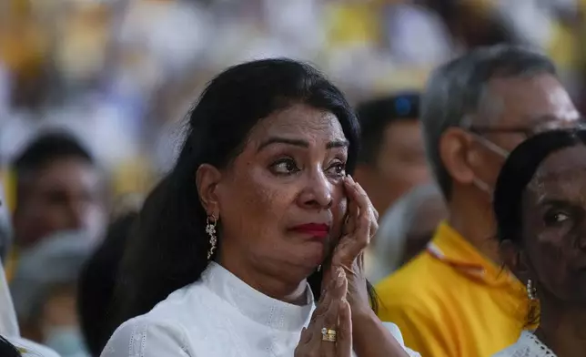 A woman gets emotional as Pope Francis presides over a mass 'In Memory of the Most Holy Name of Mary' celebrated by the Archbishop of Singapore, Cardinal William Goh Seng Chye at the Singapore SportsHub National Stadium, Thursday, Sept. 12, 2024. Pope Francis has praised Singapore's economic development as a testament to human ingenuity. But he's urging the city-state to look after the weakest too. Francis made the remarks Thursday on the final leg of the longest and farthest tour of his papacy. (AP Photo/Gregorio Borgia)