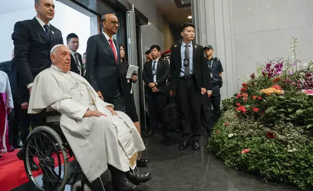 Pope Francis arrives with the President of the Singapore Republic Tharman Shanmugaratnam, third from left, for a visit to the Parliament House in Singapore, Thursday, Sept. 12, 2024. Pope Francis flew to Singapore on Wednesday for the final leg of his trip through Asia, arriving in one of the world's richest countries from one of its poorest after a record-setting final Mass in East Timor. (AP Photo/Gregorio Borgia)