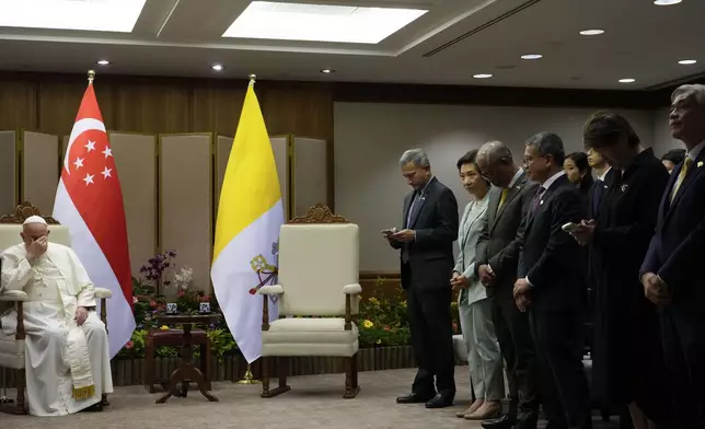 Pope Francis, left, waits for the Prime Minister of Singapore, Lawrence Wong at the Parliament House in Singapore, Thursday, Sept. 12, 2024. Pope Francis flew to Singapore on Wednesday for the final leg of his trip through Asia, arriving in one of the world's richest countries from one of its poorest after a record-setting final Mass in East Timor. (AP Photo/Gregorio Borgia, pool)