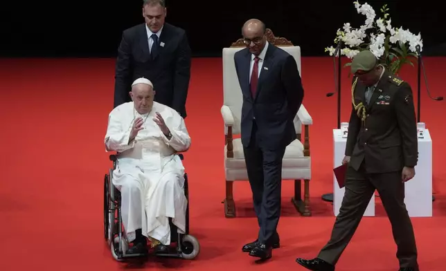 Pope Francis and Singapore's President Tharman Shanmugaratnam, third from left, leave at the end of a meeting with the authorities, civil society and the diplomatic corps in the theatre of the Cultural Centre of the National University of Singapore, Thursday, Sept. 12, 2024. Pope Francis flew to Singapore on Wednesday for the final leg of his trip through Asia, arriving in one of the world's richest countries from one of its poorest after a record-setting final Mass in East Timor. (AP Photo/Gregorio Borgia)