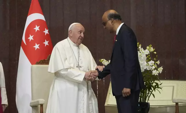 Pope Francis is greeted by the President of the Singapore Republic Tharman Shanmugaratnam, right, during a welcome ceremony at the Parliament House in Singapore, Thursday, Sept. 12, 2024. Pope Francis flew to Singapore on Wednesday for the final leg of his trip through Asia, arriving in one of the world's richest countries from one of its poorest after a record-setting final Mass in East Timor. (AP Photo/Gregorio Borgia)