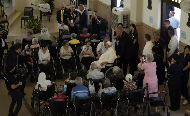 Pope Francis meets with a group of elderly and sick people at the St. Theresa's Home in Singapore, Friday, Sept. 13, 2024. Pope Francis is wrapping up his visit to Singapore by praising its tradition of interfaith harmony. (AP Photo/Gregorio Borgia)