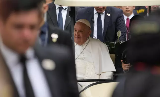 Pope Francis travels in a buggy after he arrived in Singapore, Wednesday, Sept. 11, 2024. (AP Photo/Vincent Thian)