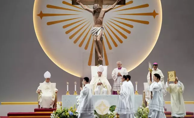 Pope Francis, seated center, presides over a holy mass at the SportsHub National Stadium in Singapore, Thursday, Sept. 12, 2024. (AP Photo/Vincent Thian)