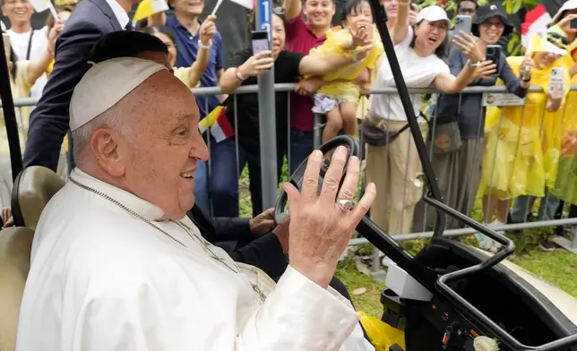 Pope Francis waves to greet the volunteers on his arrival in Singapore, Wednesday, Sept. 11, 2024. (AP Photo/Vincent Thian)