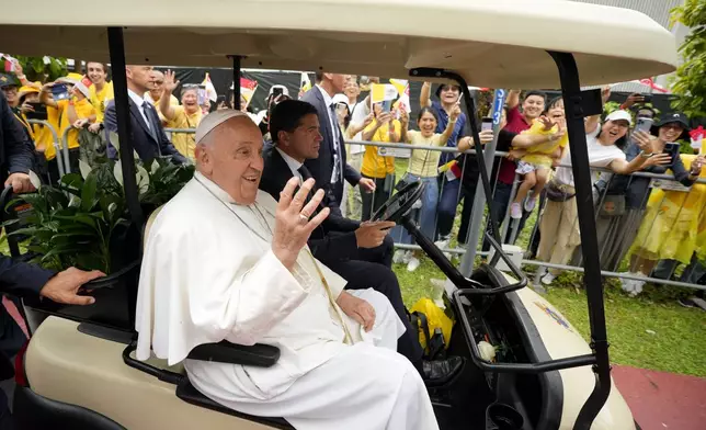 Pope Francis greets the volunteers on his arrival in Singapore, Wednesday, Sept. 11, 2024. (AP Photo/Vincent Thian)