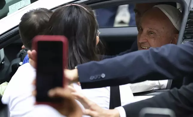 Pope Francis blesses a child as he departs National University of Singapore after delivering the state address in Singapore, Thursday, Sept. 12, 2024.(AP Photo/Suhaimi Abdullah)