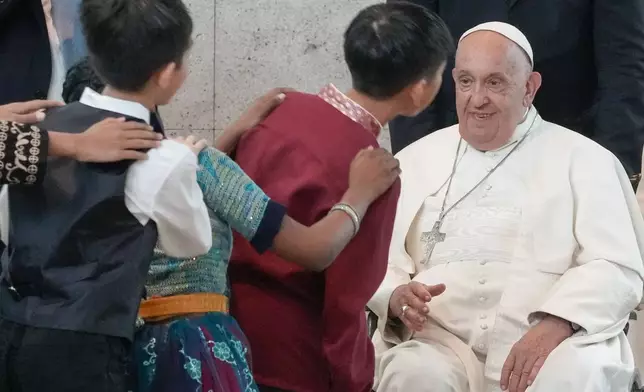 Pope Francis is welcomed by dancing children as he arrives at Singapore Changi International Airport, Wednesday, Sept. 11, 2024. Pope Francis is heading to Singapore for the final leg of his 11-day trip to Asia and Oceania. (AP Photo/Gregorio Borgia)