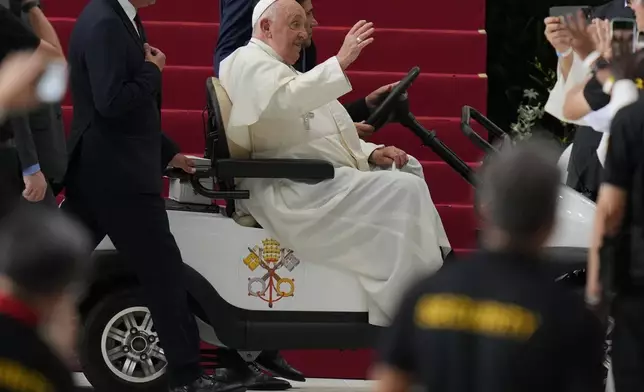 Pope Francis waves as he arrives to lead a holy mass at the SportsHub National Stadium in Singapore, Thursday, Sept. 12, 2024. (AP Photo/Vincent Thian)