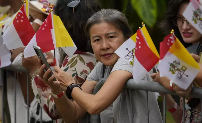 Volunteers wait to greet Pope Francis on his arrival in Singapore, Wednesday, Sept. 11, 2024. (AP Photo/Vincent Thian)