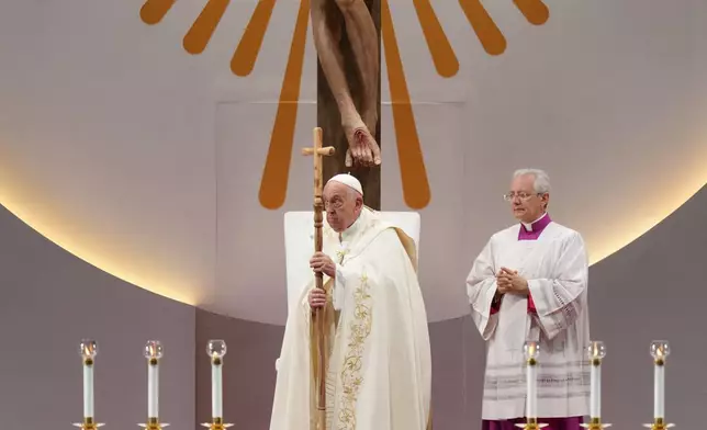 Pope Francis, left, leads a holy mass at the SportsHub National Stadium in Singapore, Thursday, Sept. 12, 2024. (AP Photo/Vincent Thian)