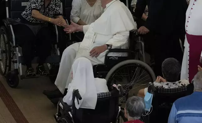 Pope Francis meets with a group of elderly and sick people at the St. Theresa's Home in Singapore, Friday, Sept. 13, 2024. Pope Francis is wrapping up his visit to Singapore by praising its tradition of interfaith harmony. (AP Photo/Gregorio Borgia)