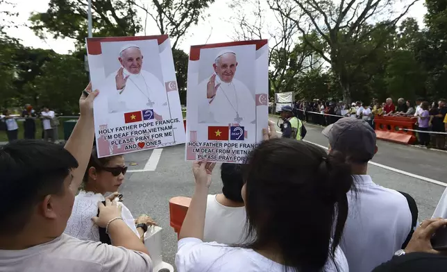 People wait for Pope Francis to arrive outside St Theresa's Home in Singapore, Friday, Sept. 13, 2024. (AP Photo/Suhaimi Abdullah)