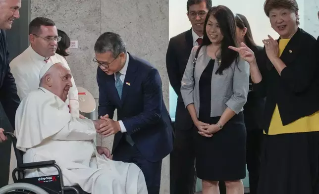 From left, Pope Francis is welcomed by Singapore's Minister of Culture, Community and Youth Edwin Tong and his wife (name not given) and the Ambassador of Singapore to the Holy See Ang Janet Guat Har as he arrives at Singapore Changi International Airport, Wednesday, Sept. 11, 2024. Pope Francis is heading to Singapore for the final leg of his 11-day trip to Asia and Oceania. (AP Photo/Gregorio Borgia)