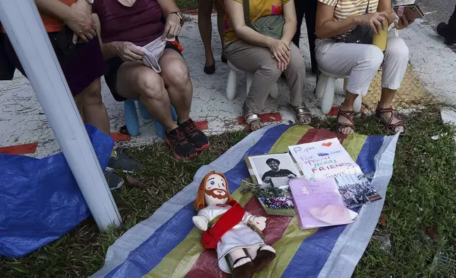 People wait for Pope Francis to arrive outside St Theresa's Home in Singapore, Friday, Sept. 13, 2024. (AP Photo/Suhaimi Abdullah)