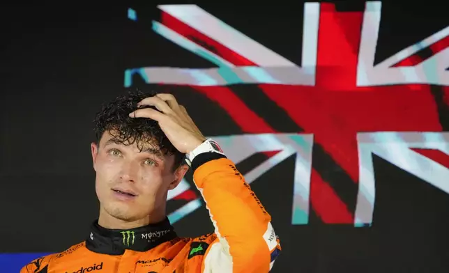 McLaren driver Lando Norris of Britain reacts on the podium after winning the Singapore Formula One Grand Prix at the Marina Bay Street Circuit, in Singapore, Sunday, Sept. 22, 2024. (AP Photo/Vincent Thian)