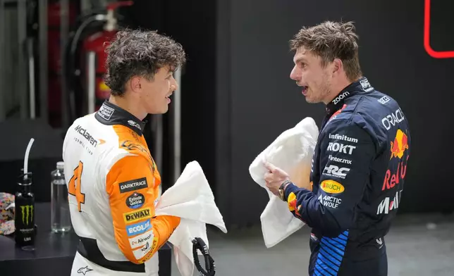 McLaren driver Lando Norris of Britain, left, talks with second placed Red Bull driver Max Verstappen of the Netherlands after qualifying session of the Singapore Formula One Grand Prix at the Marina Bay Street Circuit, in Singapore, Saturday, Sept. 21, 2024. (AP Photo/Vincent Thian)