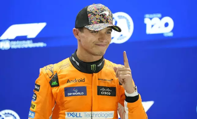 McLaren driver Lando Norris of Britain, centre, celebrates his pole position after qualifying session of the Singapore Formula One Grand Prix at the Marina Bay Street Circuit, in Singapore, Saturday, Sept. 21, 2024. (AP Photo/Vincent Thian)