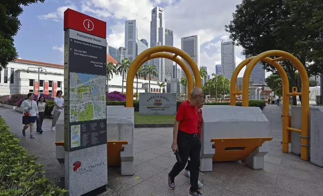 People walk outside Parliament House complex, where Pope Francis is scheduled to meet Singapore Prime Minister Lawrence Wong and President Tharman Shanmugaratnam, in Singapore, Saturday, Sept. 7, 2024. (AP Photo/Suhaimi Abdullah)