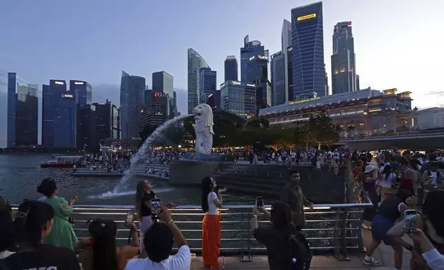 People take photos at Merlion Park in Singapore, Saturday, Sept. 7, 2024. (AP Photo/Suhaimi Abdullah)