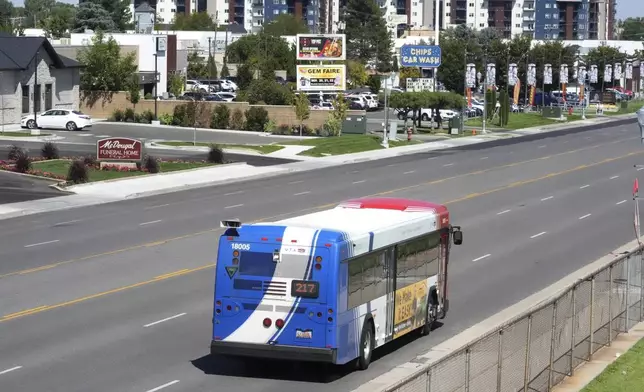 A commuter bus equipped with a radio transmitter passes a connected traffic light on Redwood Road, part of an effort to improve safety and efficiency by allowing cars to communicate with the roadside infrastructure and one another, Friday, Sept. 6, 2024, near Taylorsville, Utah. (AP Photo/Rick Bowmer)