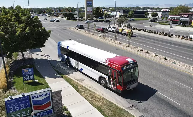 A commuter bus equipped with a radio transmitter passes a connected traffic light on Redwood Road, part of an effort to improve safety and efficiency by allowing cars to communicate with the roadside infrastructure and one another, Friday, Sept. 6, 2024, near Taylorsville, Utah. (AP Photo/Rick Bowmer)