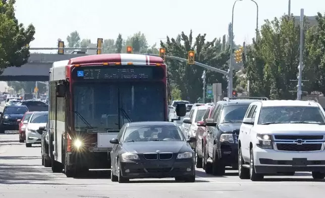 A commuter bus equipped with a radio transmitter passes a connected traffic light on Redwood Road, part of an effort to improve safety and efficiency by allowing cars to communicate with the roadside infrastructure and one another on Friday, Sept. 6, 2024, near Taylorsville, Utah. (AP Photo/Rick Bowmer)