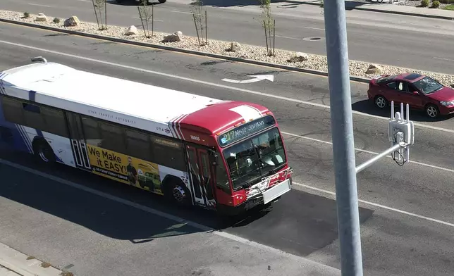 A commuter bus equipped with a radio transmitter approaches a connected traffic light on Redwood Road in Salt Lake City, part of an effort to improve safety and efficiency by allowing cars to communicate with the roadside infrastructure and one another, Friday, Sept. 6, 2024, near Taylorsville, Utah. (AP Photo/Rick Bowmer)