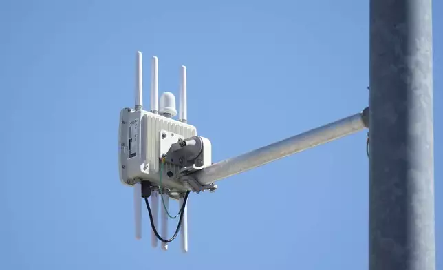 A radio transmitter hangs from a traffic light pole as it transmits to equipped commuter buses on Redwood Road, part of an effort to improve safety and efficiency by allowing cars to communicate with the roadside infrastructure and one another, Friday, Sept. 6, 2024, near Salt Lake City. (AP Photo/Rick Bowmer)