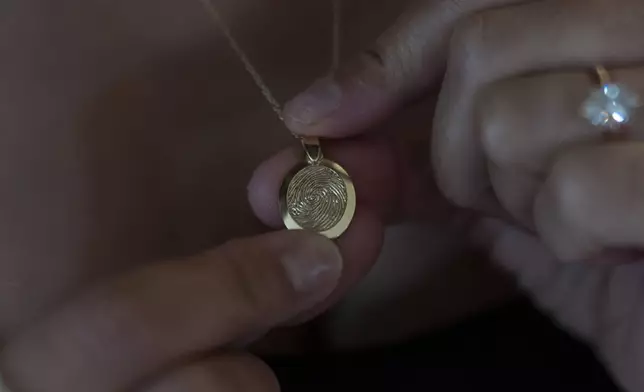 Mikayla Brown shows a pendant etched with the fingerprint of her son, Elijah Ott, who died of a fentanyl overdose at 15, in Atascadero, Calif., Friday, Aug. 2, 2024. (AP Photo/Jae C. Hong)