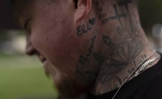 With his stepson's name tattooed below his ear, Tyler Brown, stepfather of Elijah Ott, who died of a fentanyl overdose at 15, looks at a park bench dedicated to Elijah in Paso Robles, Calif., Friday, Aug. 2, 2024. (AP Photo/Jae C. Hong)