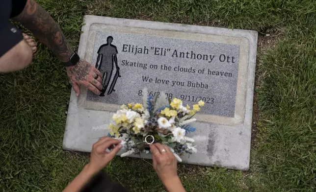 Mikayla Brown and her husband, Tyler, visit the grave of their son, Elijah, who died of a fentanyl overdose at 15, in Paso Robles, Calif., Friday, Aug. 2, 2024. (AP Photo/Jae C. Hong)