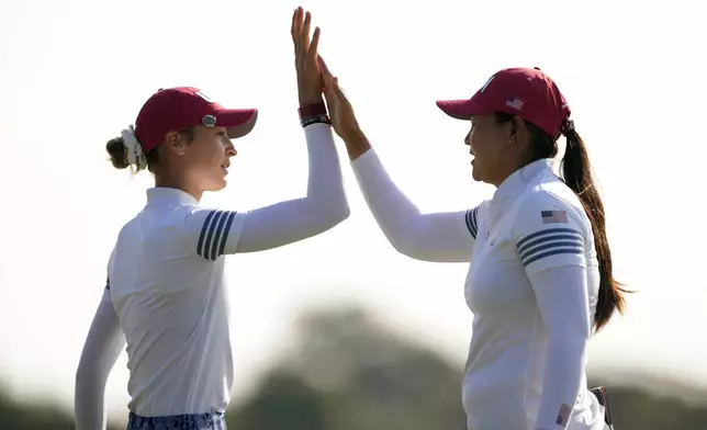 United States' Nelly Korda, left, is celebrates with teammate Allisen Corpuz after sinking a putt on the 10th hole during a Solheim Cup golf tournament foursome match at Robert Trent Jones Golf Club, Saturday, Sept. 14, 2024, in Gainesville, Va. (AP Photo/Matt York)