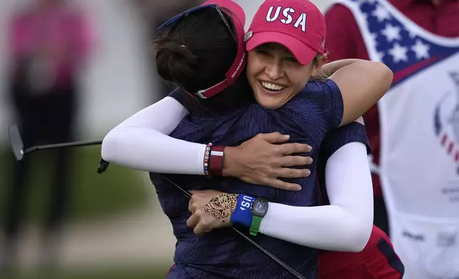 United States' Nelly Korda, right, and teammate Megan Khang hug while celebrating their victory during a Solheim Cup golf tournament fourball match at Robert Trent Jones Golf Club, Friday, Sept. 13, 2024, in Gainesville, Va. (AP Photo/Matt York)