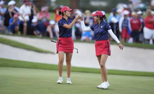 United States' Andrea Lee, left, and teammate Rose Zhang celebrate after winning a fourball match during a Solheim Cup golf tournament at Robert Trent Jones Golf Club, Friday, Sept. 13, 2024, in Gainesville, Va. (AP Photo/Chris Szagola)