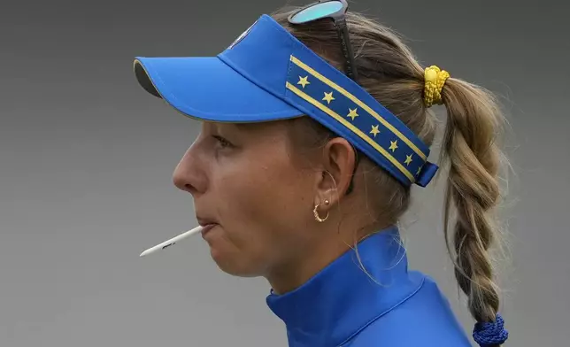 Europe's Emily Pedersen holds a tee in her mouth on the 10th hole during a Solheim Cup golf tournament foursomes match at Robert Trent Jones Golf Club, Friday, Sept. 13, 2024, in Gainesville, VA. (AP Photo/Matt York)